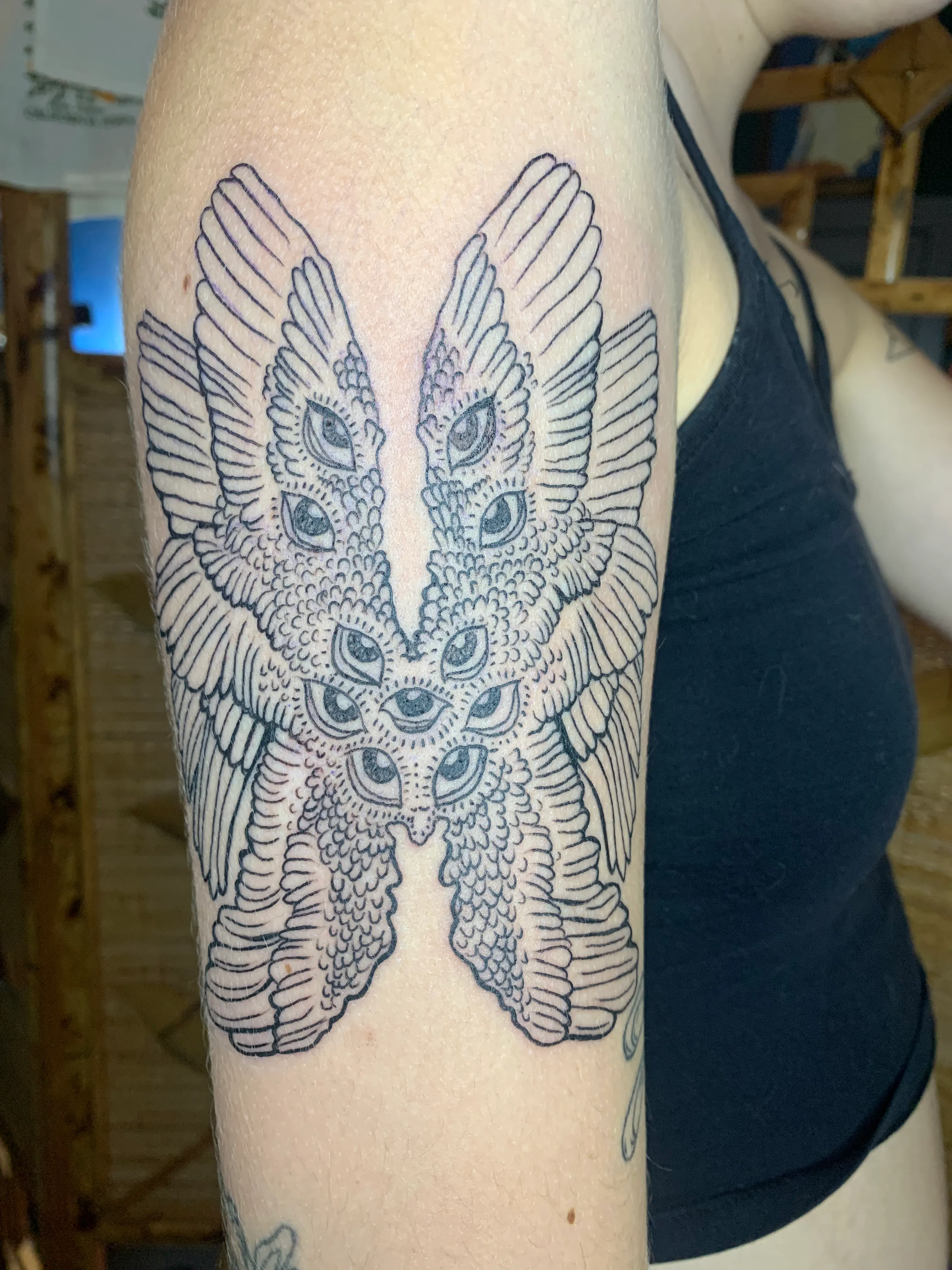 A large butterfly like creature with multiple eyes tattoo.